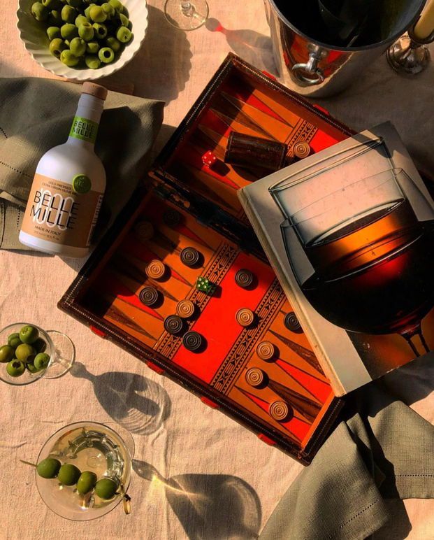a table with wine glasses, olives and a bottle of wine